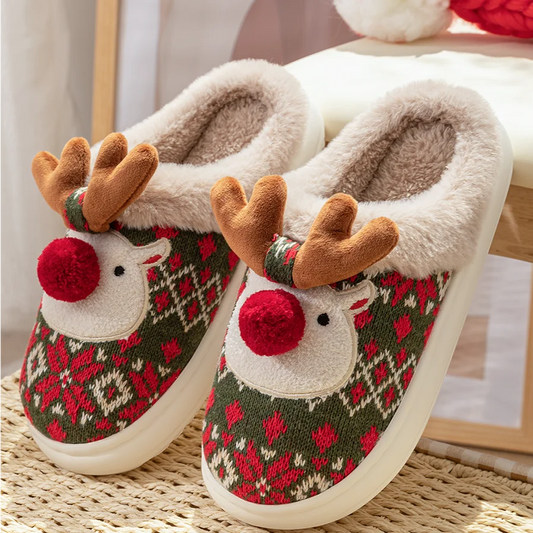 Pair of reindeer-themed slippers with patterned design on a woven surface.