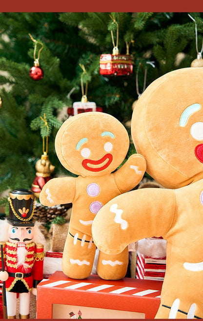 Plush gingerbread man toys in front of a decorated Christmas tree with ornaments.