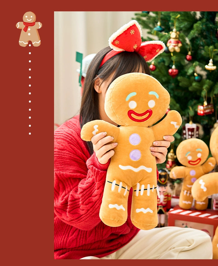 Person holding a plush gingerbread man toy with a Christmas tree in the background