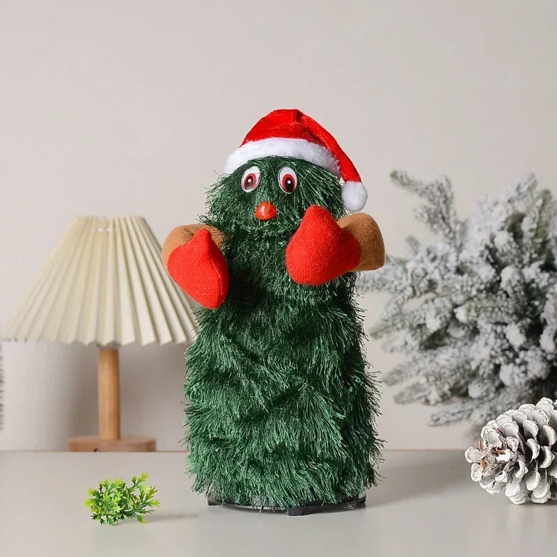Green plush toy resembling a Christmas tree with a red Santa hat and red gloves on a neutral background.