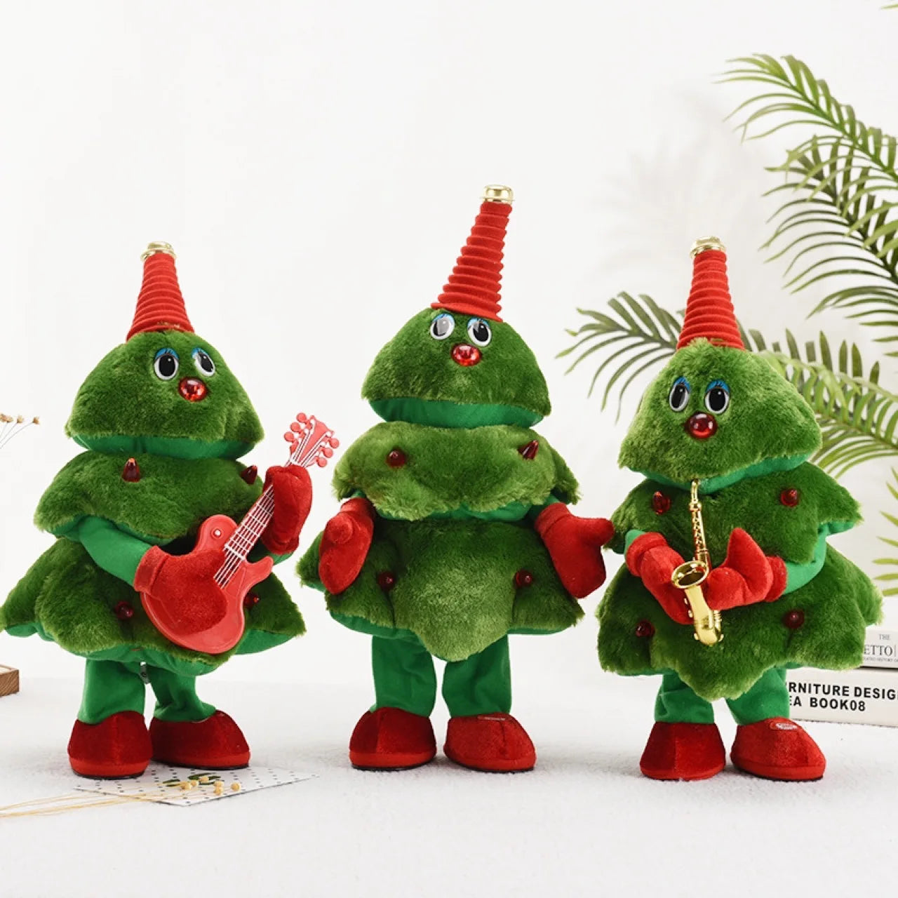 Three green plush Christmas tree toys with red hats, playing instruments on a white background.