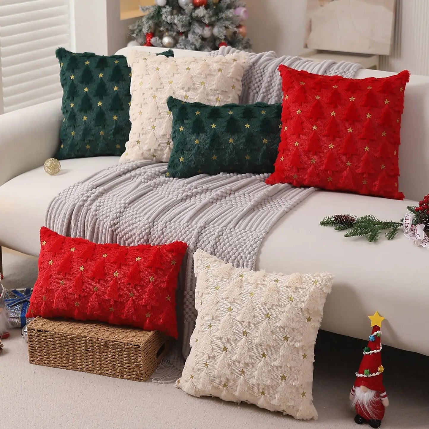 Decorative pillows on a couch with Christmas-themed decorations in a living room.