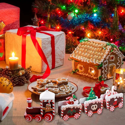 Christmas-themed table setting with gingerbread house, cookies, and decorative train in front of a lit Christmas tree.