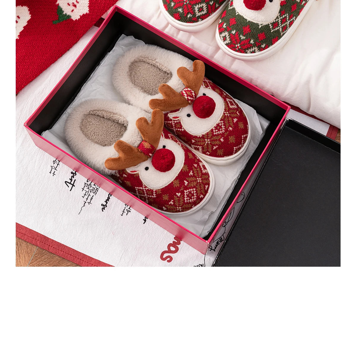 Pair of reindeer-themed slippers in a decorative box with a red and white design.