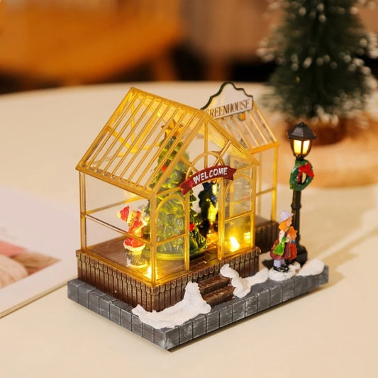 Miniature model of a greenhouse with decorative elements on a table.