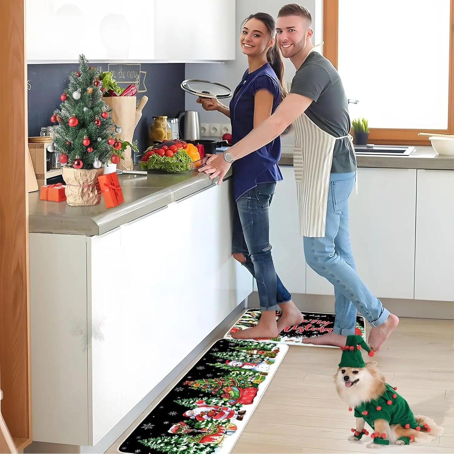 Couple in a kitchen with a dog wearing a Christmas-themed sweater, standing on a decorative rug.