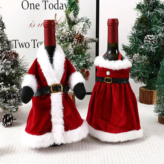 Two wine bottles in Santa Claus costumes on a textured surface with Christmas trees in the background.