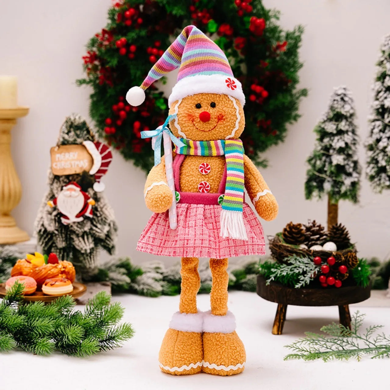 Gingerbread doll with a colorful hat and scarf in a festive setting with Christmas decorations.