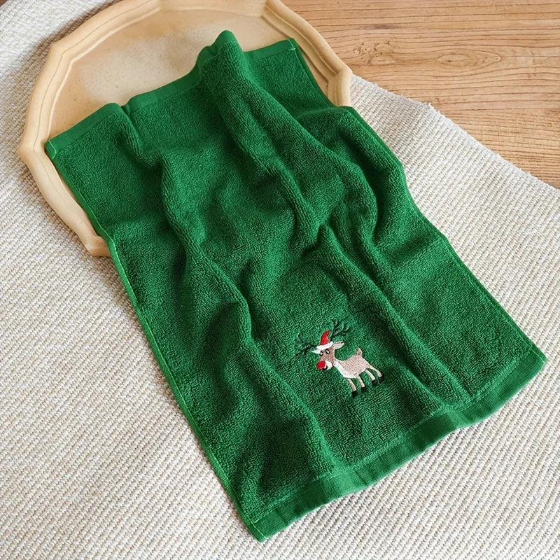 Green towel with a reindeer design on a wooden surface