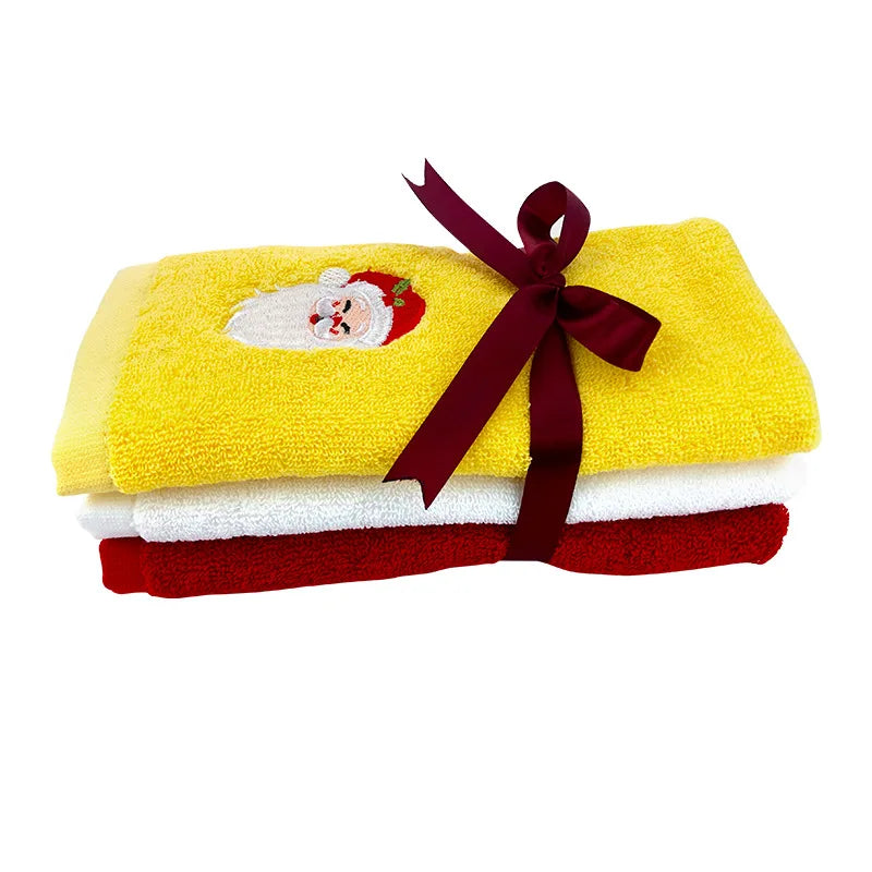 Set of yellow, white, and red towels with a Santa Claus design and a red ribbon on a white background.
