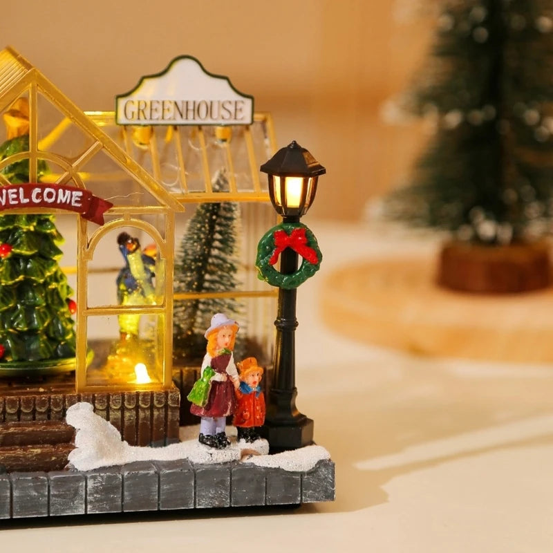 Miniature Christmas scene with a greenhouse, children, and a lamp post with a wreath.