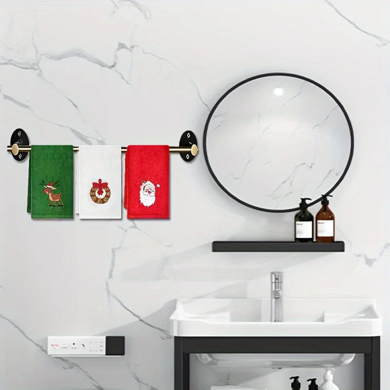 Bathroom setup with a round mirror, towel rack with Christmas-themed towels, and a sink.