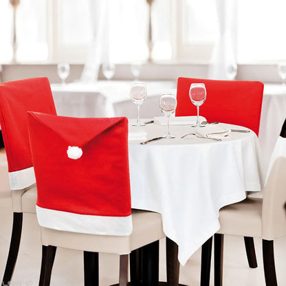 Dining table set with chairs covered in Santa hats in a bright room.