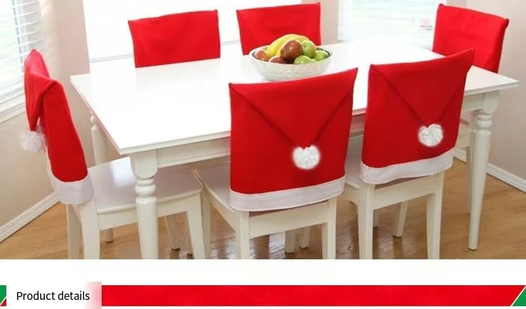 Dining table with chairs covered in red Santa hats, set against a neutral wall.
