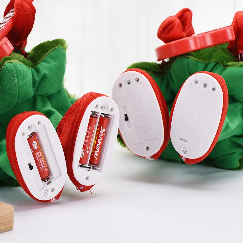 Green plush toy with red and white electronic components on a white background