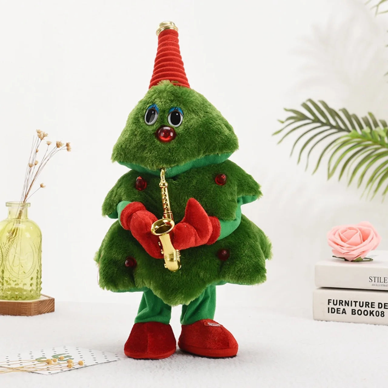 Plush toy resembling a Christmas tree with a red hat and scarf, playing a saxophone, on a white background.