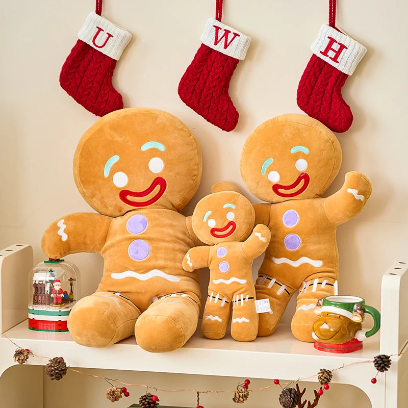 Plush gingerbread family with stockings hanging above on a shelf.