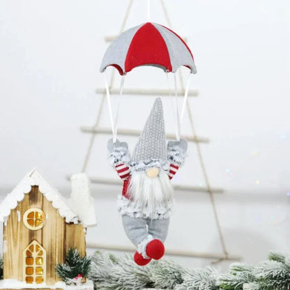 Decorative gnome with a red and gray hat hanging from a string with a white background.