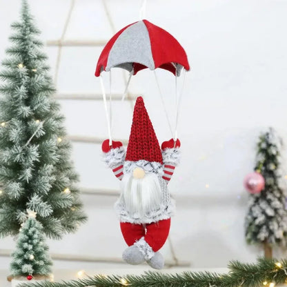 Decorative gnome with red and gray hat hanging against a Christmas tree background