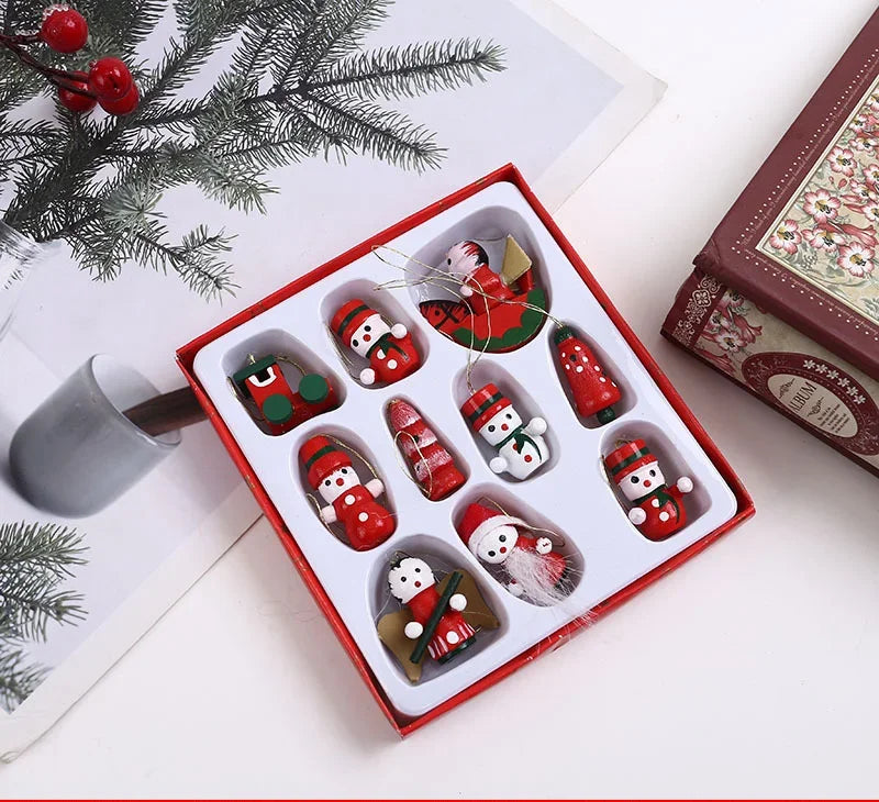 Box of Christmas-themed cookies with snowmen and Santa hats on a white surface with a mug and decorative branches.
