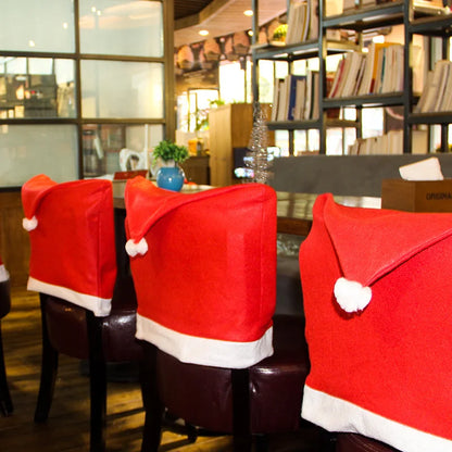 Red Santa hat covers on chairs in a restaurant setting