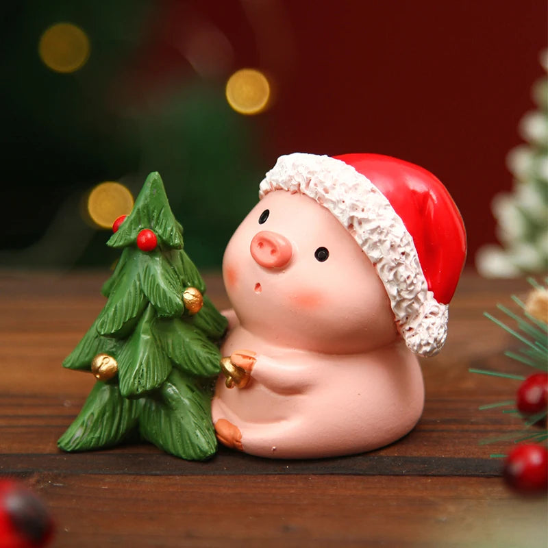 Piggy bank wearing a Santa hat with a Christmas tree on a wooden surface.