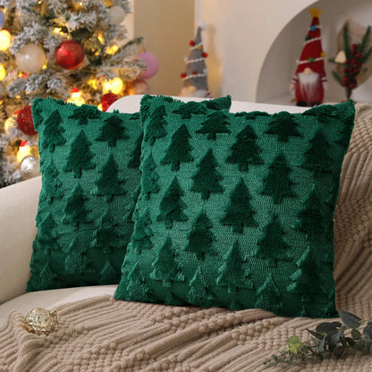 Two green textured pillows with tree pattern on a couch in a festive setting with Christmas decorations.