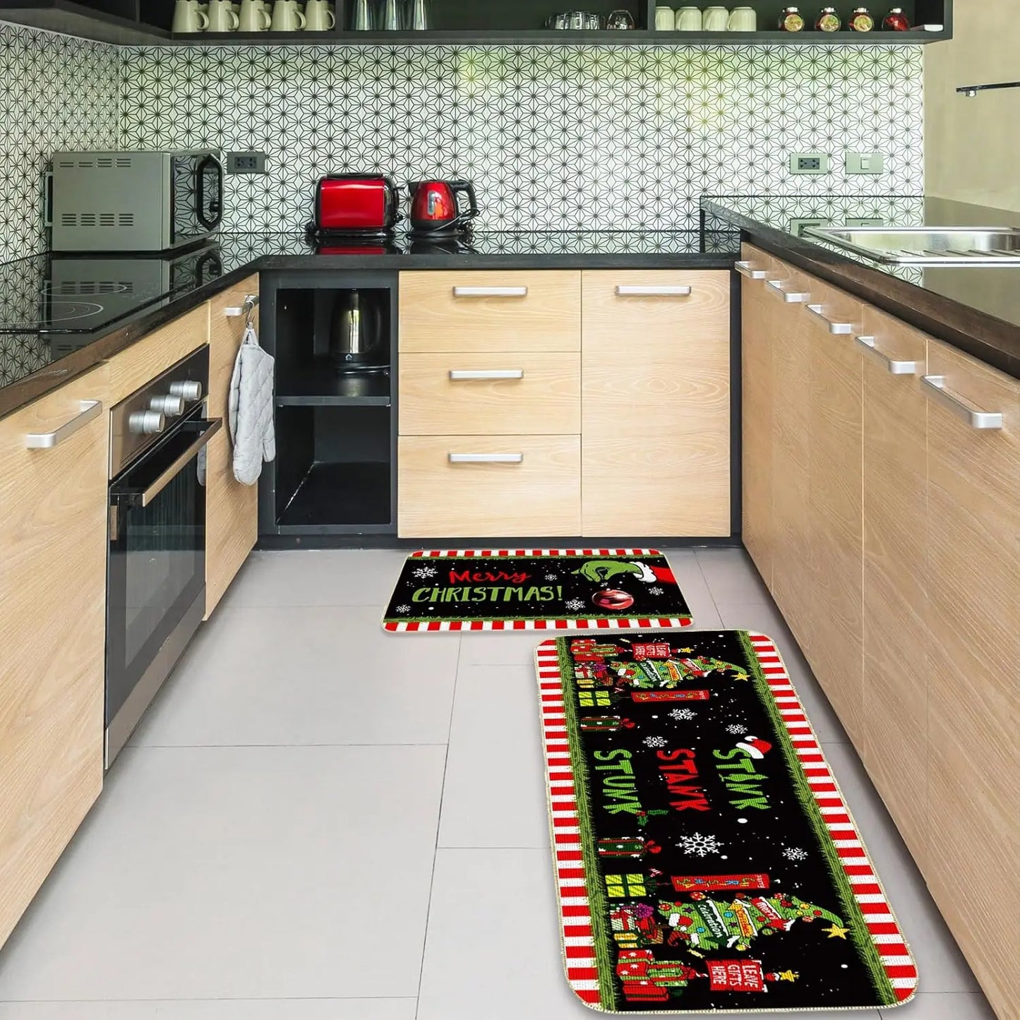 Two Christmas-themed kitchen mats on a tiled floor in a modern kitchen.