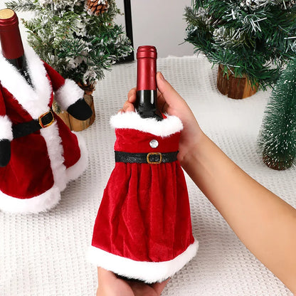 Red wine bottle in a Santa Claus costume held by a hand with Christmas decorations in the background.