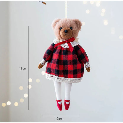 Teddy bear in a red and black checkered dress with white trim, hanging against a light background.
